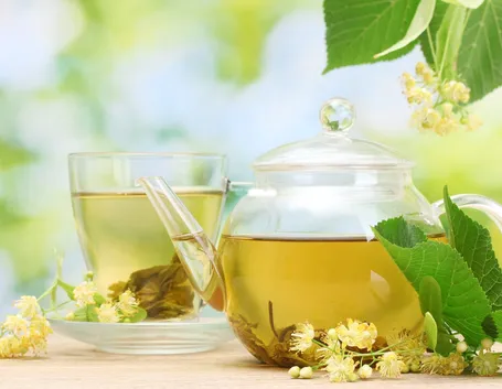 La foto mostra una tazza e una caraffa contenenti una tisana alle erbe.