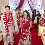 Sposi indiani indossano la tradizionale ghirlanda di rose rosse