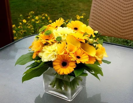 Una solare composizione di fiori gialli tra cui gerbrere e calle